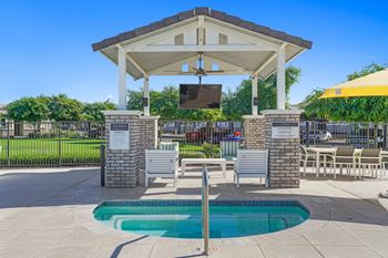 A pool area with a covered seating area and a pool.